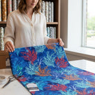 Carmon's Quilt Shop Oceana Coral 108 inch wide quilting fabric featuring orange and blue coral reef print on blue