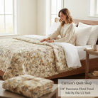 Carmon's Quilt Shop 118-inch wide Panorama tonal floral quilting cotton fabric draped over a bed with a woman.