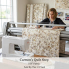 Carmon's Quilt Shop Panorama tonal floral 118-inch wide cotton quilting fabric being machine quilted by a woman.