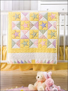 Carmon's Quilt Shop baby quilt featuring a pastel star pattern with yellow, pink, and green fabric on a crib.