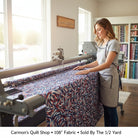 Carmon's Quilt Shop patriotic swirl 108-inch wide cotton quilt backing fabric being loaded onto a longarm machine.