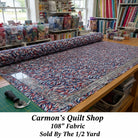 Carmon's Quilt Shop patriotic swirl 108-inch wide cotton quilt backing fabric in red, white, and blue on a cutting table