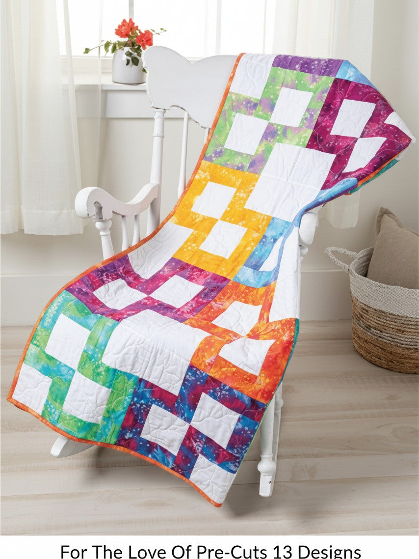 Carmon's Quilt Shop For the Love of Precuts pattern book quilt featuring a colorful rainbow block design on a chair
