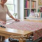 Carmon's Quilt Shop Quilting in Bloom red floral cotton fabric being measured on a table by a woman