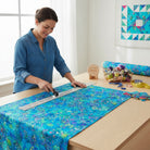 Robert Kaufman Pacific Phantasma 100% cotton fabric in fiesta blue with geometric hexagons, stars, and triangles in neon green, pink, and yellow.