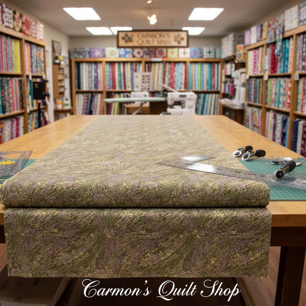Carmon's Quilt Shop Meadow Breeze sage green floral 108-inch wide cotton quilt backing fabric on a cutting table.