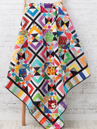 Carmon's Quilt Shop Scrap-Happy quilt featuring colorful geometric patterns and black and white fabric accents