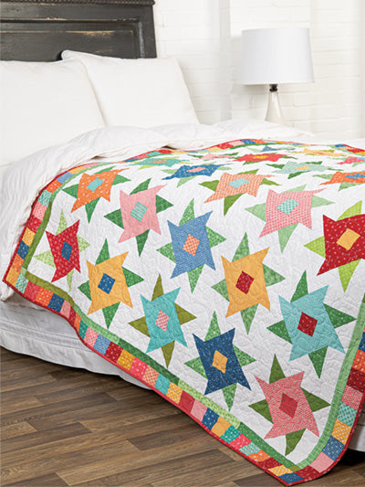 Carmon's Quilt Shop Scrap-Happy quilt pattern book featuring a colorful star-patterned quilt on a bed