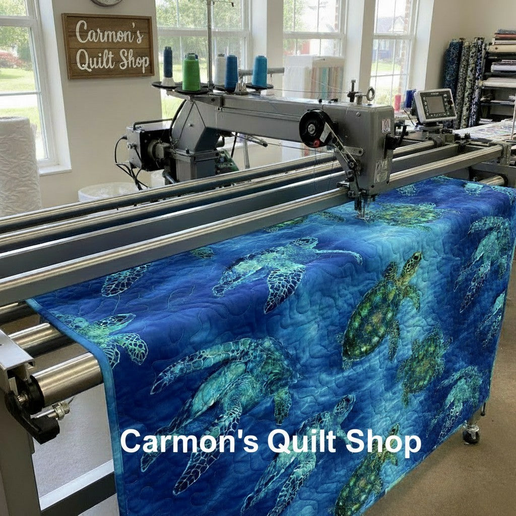 Carmon's Quilt Shop sea turtle patterned 108-inch cotton quilting fabric being machine quilted on a longarm frame.