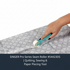 Carmon's Quilt Shop SINGER Pro Series seam roller pressing a flat seam on grey patterned fabric for quilting
