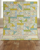 Carmon's Quilt Shop Sisterhood Floral quilt kit featuring geometric blocks in soft yellow, green, blue, and floral prints