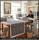 Carmon's Quilt Shop black and white spiderweb print 108-inch wide cotton quilting fabric on a sewing table.