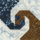 Carmon's Quilt Shop Square on Square 8-inch trim tool quilt block in blue, brown, and white fabrics.