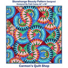 Carmon's Quilt Shop Stonehenge Beauty quilt featuring a vibrant paper-pieced star pattern in blue, red, and green tones.