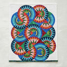 Carmon's Quilt Shop Stonehenge Beauty paper-pieced star wall hanging quilt with vibrant multi-colored geometric patterns.