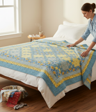 Carmon's Quilt Shop Sunny Skies quilt kit featuring blue and yellow floral fabric on a bed with a woman styling it