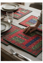 Carmon's Quilt Shop Table for Four placemats featuring red, green, and blue patchwork fabric on a wooden table.