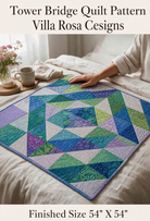 Carmon's Quilt Shop Tower Bridge quilt pattern featuring a blue, green, and purple geometric diamond design on a bed.