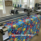 Carmon's Quilt Shop longarm machine quilting vibrant Jewel of the Sea cotton fabric with colorful tropical fish print.