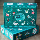 Carmon's Quilt Shop 12 Days of Christmas advent box featuring turquoise festive character illustrations