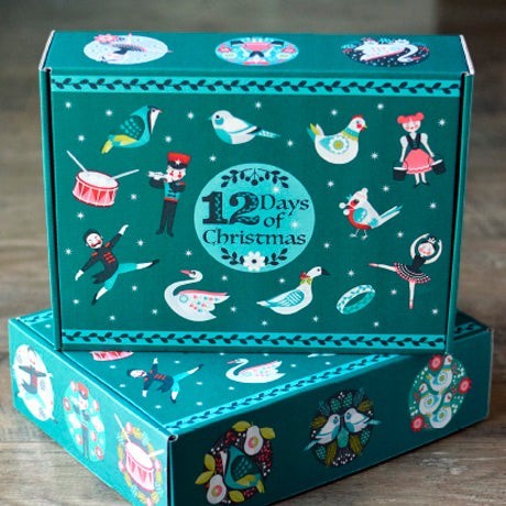 Carmon's Quilt Shop 12 Days of Christmas advent box featuring turquoise festive character illustrations