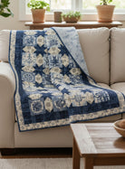 Carmon's Quilt Shop Vintage quilt pattern featuring blue and cream star motifs draped over a beige sofa.