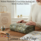 Carmon's Quilt Shop walnut geometric starburst hexagon cotton quilt backing fabric folded on a wooden table.
